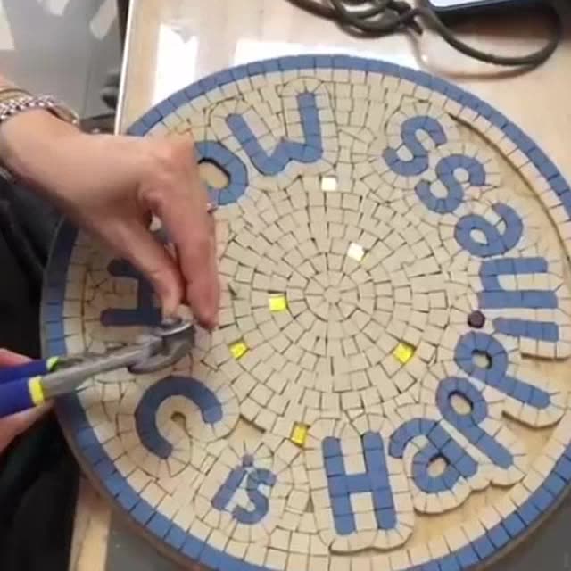 Séance en binôme à l'atelier : deux personnes posent les tesselles d'une table « Mosaic is Happiness ».